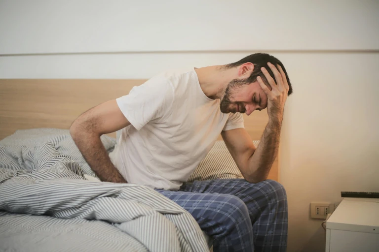 man in pain holding his head