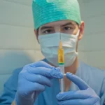 Man nurse holding a vaccine syringe