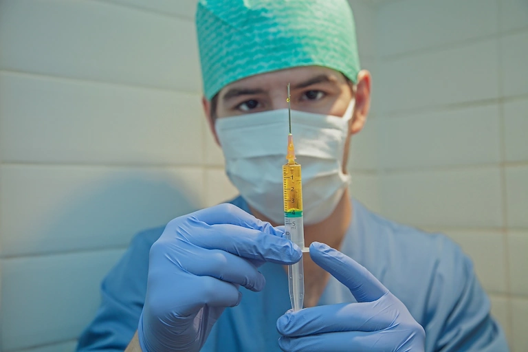 Man nurse holding a vaccine syringe