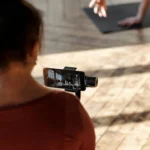 Woman films gym partner exercising