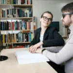 Blind man helped to read a book by woman