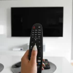 Remote control held in front of a tv