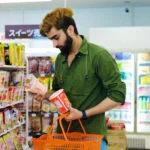 Man comparing boxes of noodles in a store