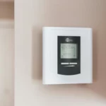 White thermostat hanging on the wall