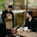 Waiter taking the order of two men sitting at a table