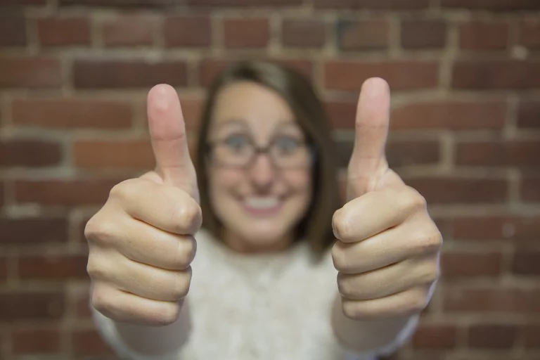 Woman smiling and giving two thumbs up