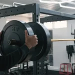 Man Adjusting Barbell Weights in Gym