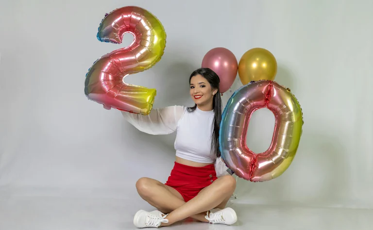 woman holding 2 and 0 balloons